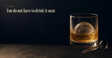 A whisky glass with a large clear ice sphere and a water dropper — You do not have to drink it neat