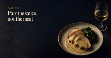 A plate of sliced pork in mustard sauce beside a glass of white wine — Pair the sauce, not the meat
