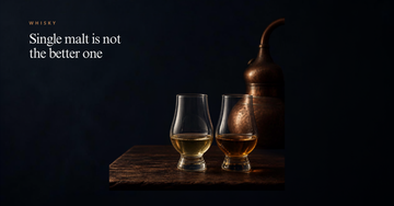 Two whisky glasses of differing colour beside a copper pot still — Single malt is not the better one