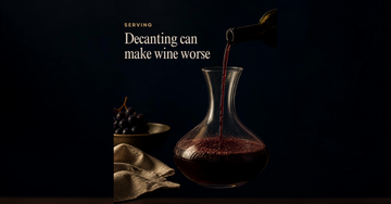 A glass decanter catches a thin pour of dark red wine from a tilted bottle, sediment settling at its shoulder — Decanting can make wine worse
