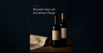 Two matching Bordeaux bottles with different coloured capsules stand close on dark wood beside a rolled vineyard map — Second wines are not always cheap