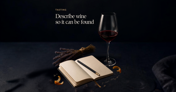 A wine glass sits beside a small notebook with a pencil across an open blank page, dried lavender and citrus peel nearby — Describe wine so it can be found