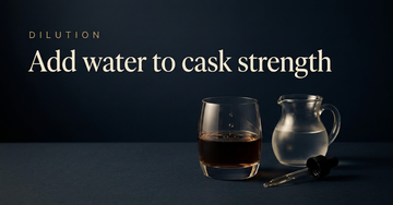 A whisky glass filled dark and undiluted, a small glass jug of water and an eyedropper beside it, faint ripples spreading — Add water to cask strength