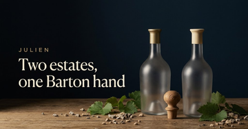 Two decanters side by side on aged oak with one hand carved stopper set between them, gravel and vine leaves scattered — Two estates, one Barton hand