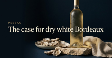 A chilled unlabelled white wine bottle sweating on limestone beside a shallow dish of oyster shells and folded linen — The case for dry white Bordeaux