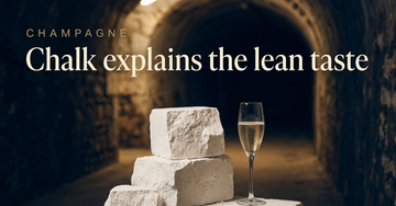 Rough white chalk blocks stacked beside a narrow flute of pale Champagne, ancient cellar tunnels curving into darkness — Chalk explains the lean taste